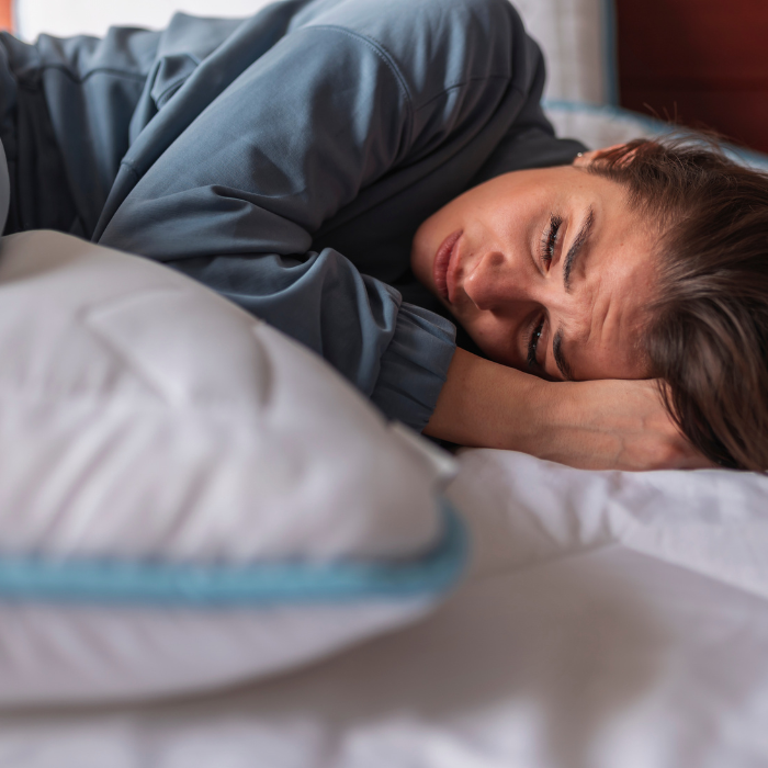 Ženska drži roke na trebuhu zaradi močnih PMS simptomov in menstrualnih bolečin