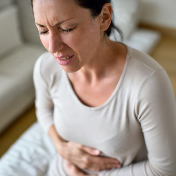 PMS simptomi: ženska z bolečinami v trebuhu in menstrualnimi krči pred obdobjem